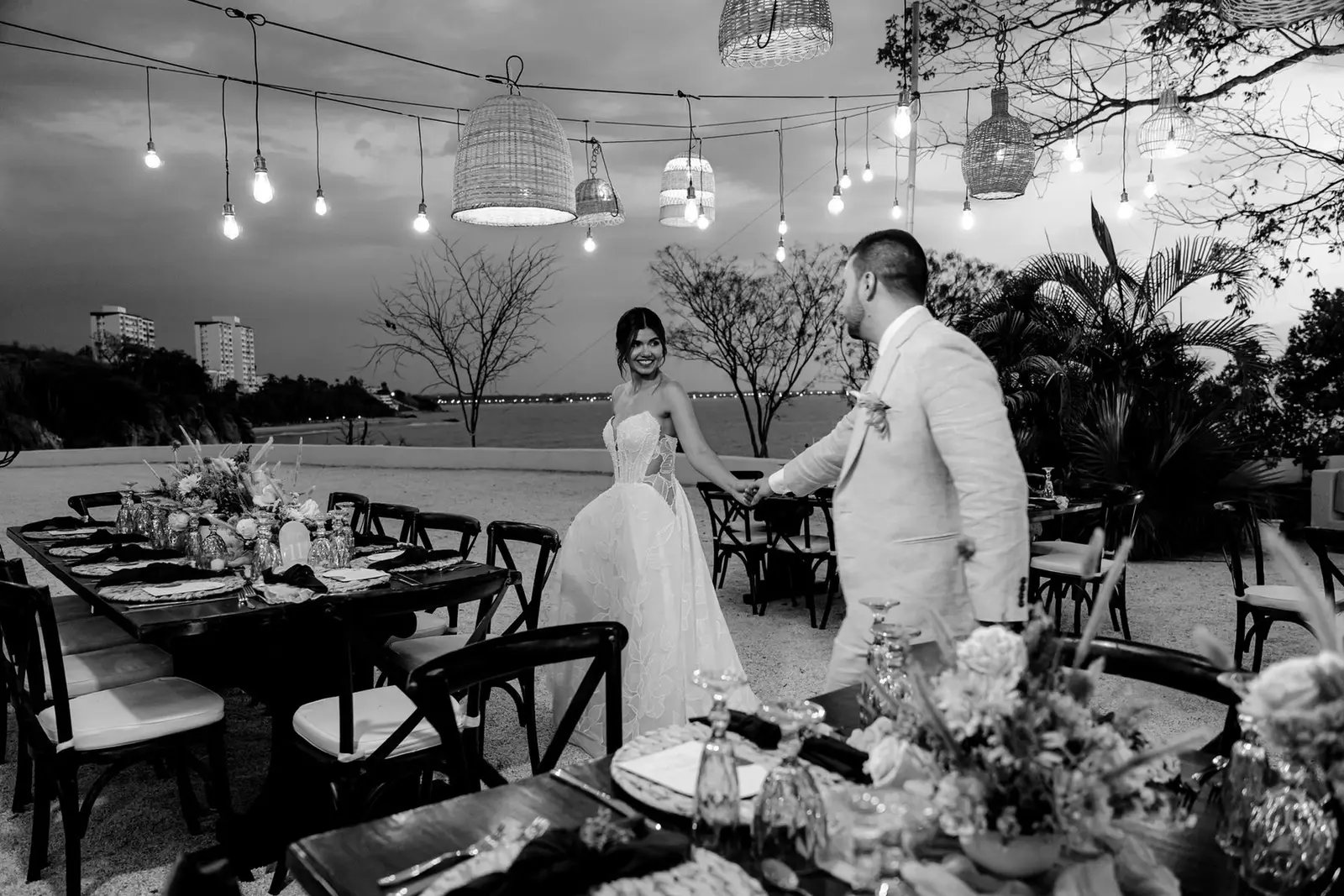 Novios en una cena al aire libre bajo luces colgantes