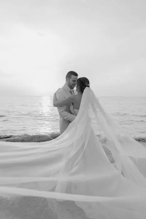 Novia con un velo largo frente al mar